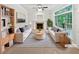 Bright staged living room featuring fireplace, large window, two couches, and area rug at 7155 Homestead Rd, Rex, GA 30273