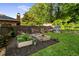 Private backyard with raised garden beds, vibrant flowers, a playhouse, and a lush green lawn at 917 Gaylemont Cir, Decatur, GA 30033