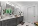 Modern bathroom with gray cabinets, double sinks, and a door to a separate toilet at 917 Gaylemont Cir, Decatur, GA 30033