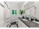 Modern bathroom with white subway tile shower, dark floors, and a window overlooking the yard at 917 Gaylemont Cir, Decatur, GA 30033