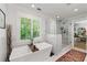 Bright bathroom with a soaking tub, frameless shower, and shuttered window view at 917 Gaylemont Cir, Decatur, GA 30033