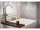 Modern bathroom featuring a soaking tub, marble tile surround, and stylish fixtures at 917 Gaylemont Cir, Decatur, GA 30033