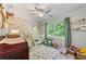 Bedroom decorated with floral wallpaper, a white crib, and views of the lush yard at 917 Gaylemont Cir, Decatur, GA 30033