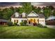 Charming white brick home featuring dormer windows and a well-manicured front yard at dusk at 917 Gaylemont Cir, Decatur, GA 30033
