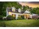 Charming white brick home featuring dormer windows and a well-manicured front yard at dusk at 917 Gaylemont Cir, Decatur, GA 30033