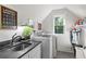 Well-lit laundry room with sink, white cabinetry, and modern appliances at 917 Gaylemont Cir, Decatur, GA 30033