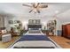 Comfortable main bedroom featuring hardwood floors, ceiling fan, area rug, and matching bedside tables at 917 Gaylemont Cir, Decatur, GA 30033
