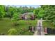 Aerial view of a brick home with lush greenery, a gated entrance, and a long driveway at 2498 Highway 212, Covington, GA 30016