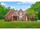 Charming two-story brick home with a well-manicured lawn and colorful flower beds at 2498 Highway 212, Covington, GA 30016