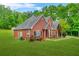 A well-kept two-story brick home showcasing its landscaped yard and part of the driveway at 2498 Highway 212, Covington, GA 30016