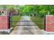 A black iron gate with brick columns adds charm to the property entrance at 2498 Highway 212, Covington, GA 30016