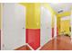 Hallway features red and yellow walls with hardwood flooring and white doors at 2498 Highway 212, Covington, GA 30016