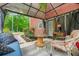 Covered outdoor patio with comfortable seating, a table, and a view of the lush greenery at 2498 Highway 212, Covington, GA 30016