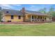 Inviting yellow home with a covered porch, lush lawn, and mature trees at 255 Deer Run Rd, Ellenwood, GA 30294