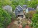 Aerial view of a charming blue house with a cozy backyard and fire pit surrounded by lush greenery at 424 Melrose Ave, Decatur, GA 30030