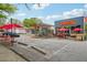 Multi-tenant commercial building featuring a cleaners, a burger joint and a restaurant, with red umbrellas at 424 Melrose Ave, Decatur, GA 30030