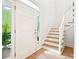 Bright foyer with a white door, staircase, and hardwood floors creating a warm entry at 424 Melrose Ave, Decatur, GA 30030