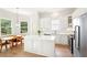 Bright kitchen with white cabinets, stainless steel appliances, and center island with dining table at 424 Melrose Ave, Decatur, GA 30030