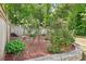 Serene landscaped yard featuring a stone bench, lush bushes, and a wooden fence at 424 Melrose Ave, Decatur, GA 30030