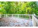 Inviting back deck with white railing offers a serene outdoor space surrounded by lush trees at 4822 Westbourne Dr, Powder Springs, GA 30127