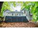 Back exterior view of home with a deck, stairs and lush greenery at 4822 Westbourne Dr, Powder Springs, GA 30127