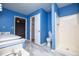 Bright bathroom features a stand-up shower, tile floor, and blue painted walls at 4822 Westbourne Dr, Powder Springs, GA 30127