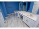 Vibrant bathroom featuring marble floors, a built-in tub, and bright blue walls at 4822 Westbourne Dr, Powder Springs, GA 30127