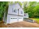 Side view of the house with gray siding, white garage doors, and steps up to the front porch at 4822 Westbourne Dr, Powder Springs, GA 30127