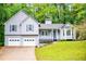 Charming two-story home featuring light gray siding, blue shutters, and a two-car garage at 4822 Westbourne Dr, Powder Springs, GA 30127