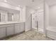 Bathroom featuring a dual sink vanity, walk-in shower, and soaking tub at 339 Elgin Dr, Lawrenceville, GA 30045