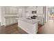Well-lit kitchen with a large island, stainless steel appliances, granite countertops, and hardwood floors at 339 Elgin Dr, Lawrenceville, GA 30045