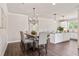 Elegant dining area with modern lighting, a stylish table setting, and a seamless flow to the kitchen at 5128 Noble Village Way # 35, Lilburn, GA 30047