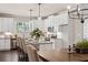 Open kitchen and dining area with white cabinets, granite counters, stainless appliances, and modern lighting at 5128 Noble Village Way # 35, Lilburn, GA 30047