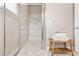 Modern shower stall with marble tiling, a built-in bench, and sleek glass doors at 5128 Noble Village Way # 35, Lilburn, GA 30047