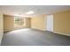 Finished basement area with neutral paint, carpeting, side access window, and a utility access door at 2055 Springer Walk, Lawrenceville, GA 30043