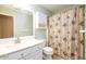 Bright bathroom featuring a white vanity, cabinet, and toilet alongside a decorative shower curtain at 2055 Springer Walk, Lawrenceville, GA 30043