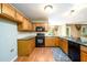 Well-equipped kitchen with wooden cabinets, black appliances, and a sink under the window at 2055 Springer Walk, Lawrenceville, GA 30043