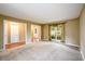A carpeted living room with a large window, neutral walls, and a view into the entry and hall at 2055 Springer Walk, Lawrenceville, GA 30043