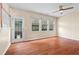 Bright living room with hardwood floors, a ceiling fan, and a glass door that leads to the backyard at 216 Diamond Valley Pass, Canton, GA 30114
