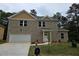 Two-story brick home featuring an attached garage and a well-manicured front lawn at 3368 Bonnes Ct, Ellenwood, GA 30294