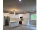 Modern kitchen with an island, stainless steel appliances, white cabinets, and gray floors at 3368 Bonnes Ct, Ellenwood, GA 30294