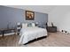 Relaxing bedroom showcasing blue accent wall, wood floors, accent lamps and cozy recliner at 3999 Wabash Ln, Ellenwood, GA 30294