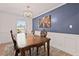 Dining room with a chandelier, wainscoting and a blue accent wall at 3999 Wabash Ln, Ellenwood, GA 30294