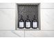 Close up of recessed shower niche with black tile, filled with shampoo, body wash and conditioner bottles at 831 Catherine St, Forest Park, GA 30297