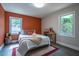 Inviting bedroom with an orange accent wall, comfortable bed, and natural light, creating a warm ambiance at 831 Catherine St, Forest Park, GA 30297