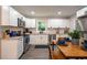 Modern kitchen featuring white cabinets, stainless steel appliances, granite counters, and a dining area at 831 Catherine St, Forest Park, GA 30297