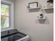 Washer in laundry room, beside floating shelves with a charming laundry room sign at 831 Catherine St, Forest Park, GA 30297
