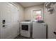 Bright laundry room with modern washer and dryer units, next to a door with a digital lock at 831 Catherine St, Forest Park, GA 30297