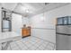 Kitchenette area featuring a small refrigerator, sink, microwave and white tile flooring at 488 Russell Rd, Lawrenceville, GA 30043