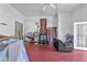 Spacious living room featuring red concrete floors, a partial staircase, and natural light from the doorway at 488 Russell Rd, Lawrenceville, GA 30043